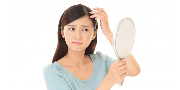手鏡で髪の毛を見る女性